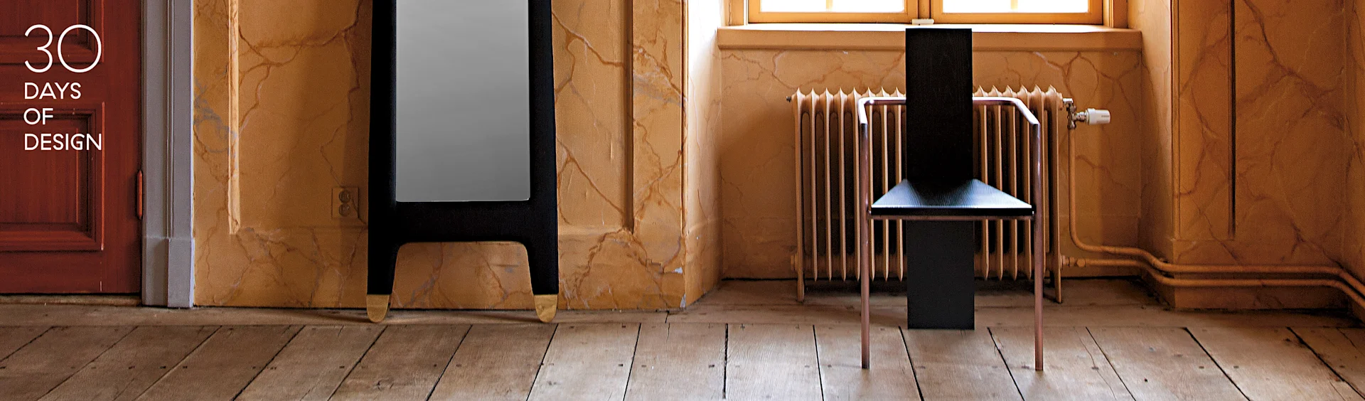Chaise noire moderne aux pieds en cuivre, grand miroir sombre aux pieds dorés, dans une pièce aux murs texturés. Texte: 30 DAYS OF DESIGN.