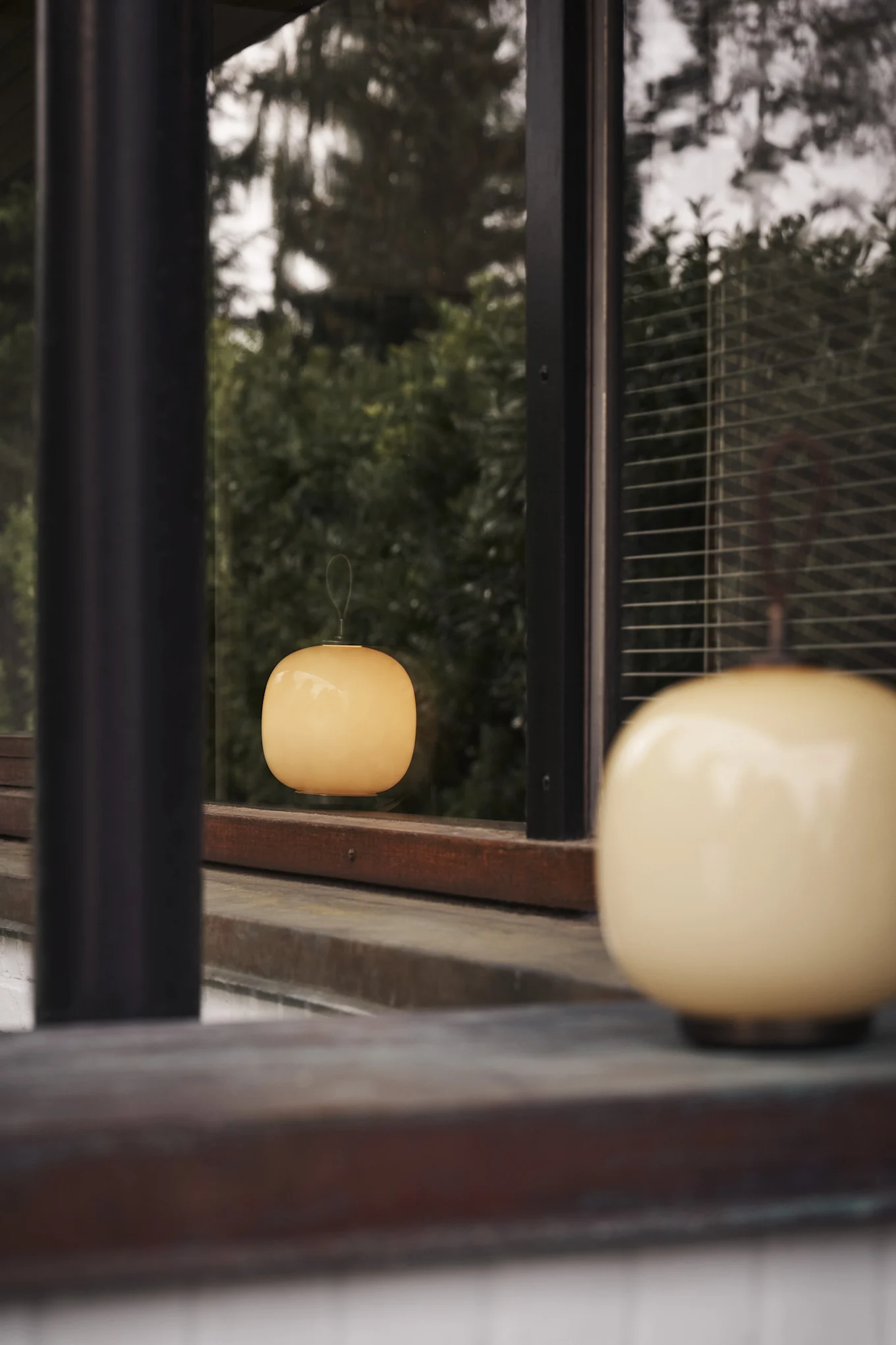 La lampe rechargeable VL45 de Louis Poulsen éclaire l'extérieur d'une lumière chaude.