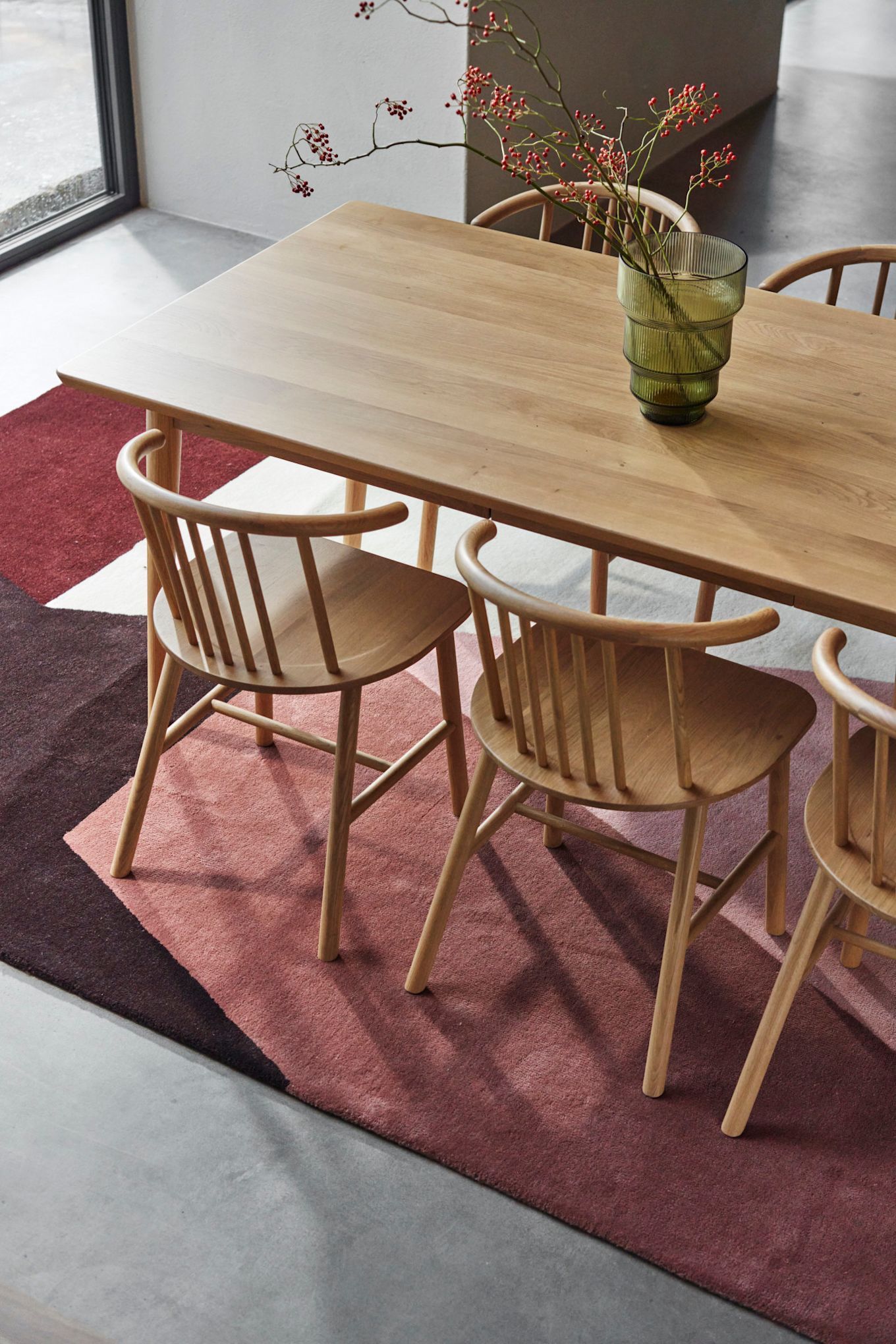 Tapis pour la salle à manger : Le tapis Aspect en laine de NJRD se trouve dans la salle à manger sous les meubles de cuisine en bois de la collection Vior de NJRD.