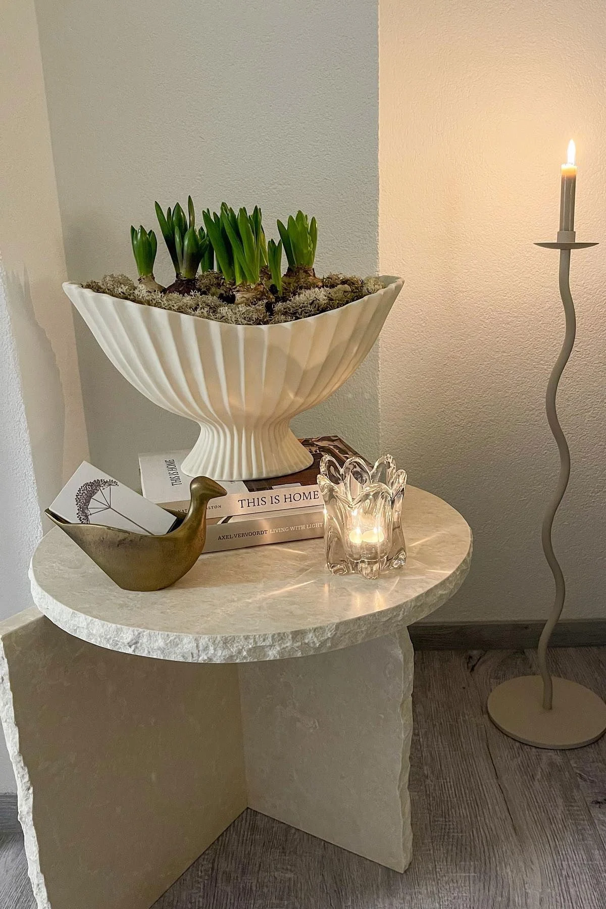 La table Mineral Sculptural est décorée avec la coupe Fountain, toutes deux de Ferm Living, et d'autres petits objets. À côté se trouve le grand bougeoir Curved de Cooee Design.