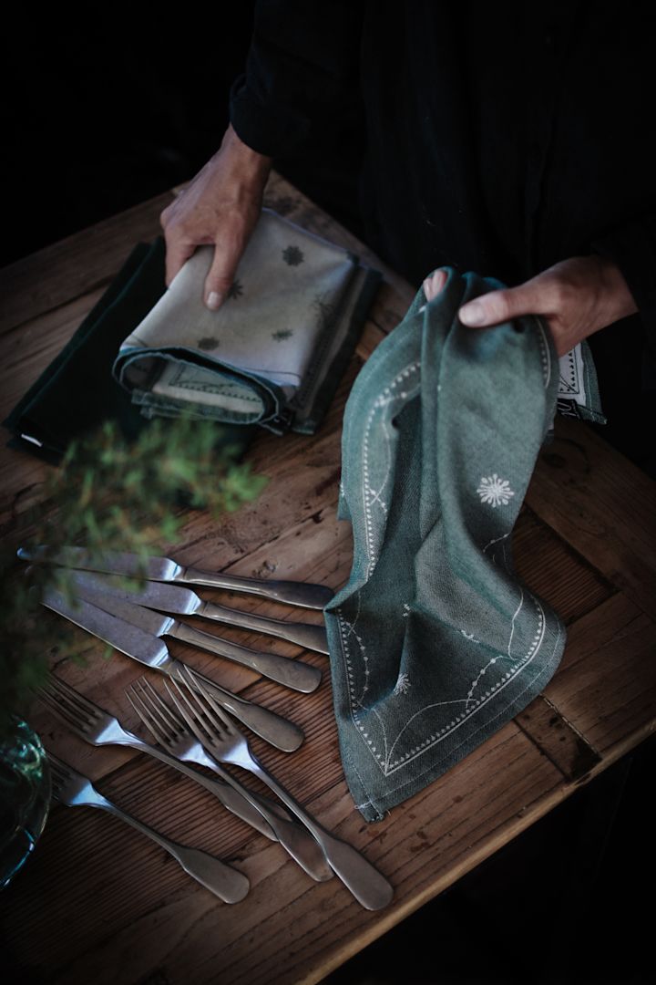 Une table avec des couverts et des serviettes Julemorgen de Wik & Walsøe.