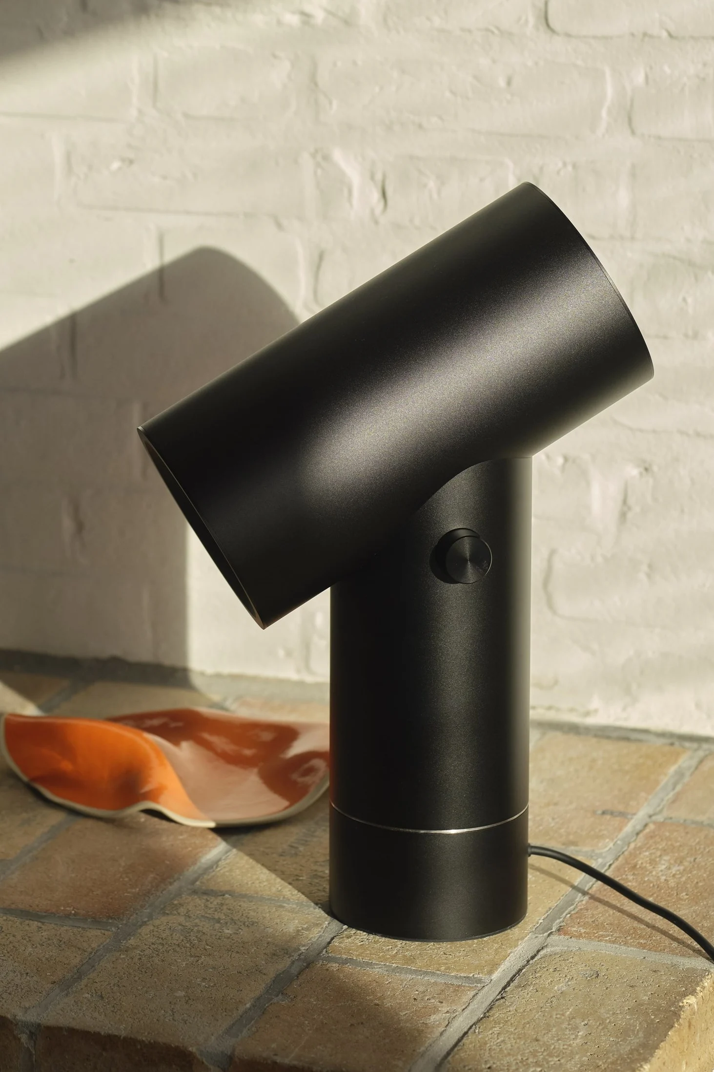 La lampe de table Beam noire de Muuto dans un décor carrelé.