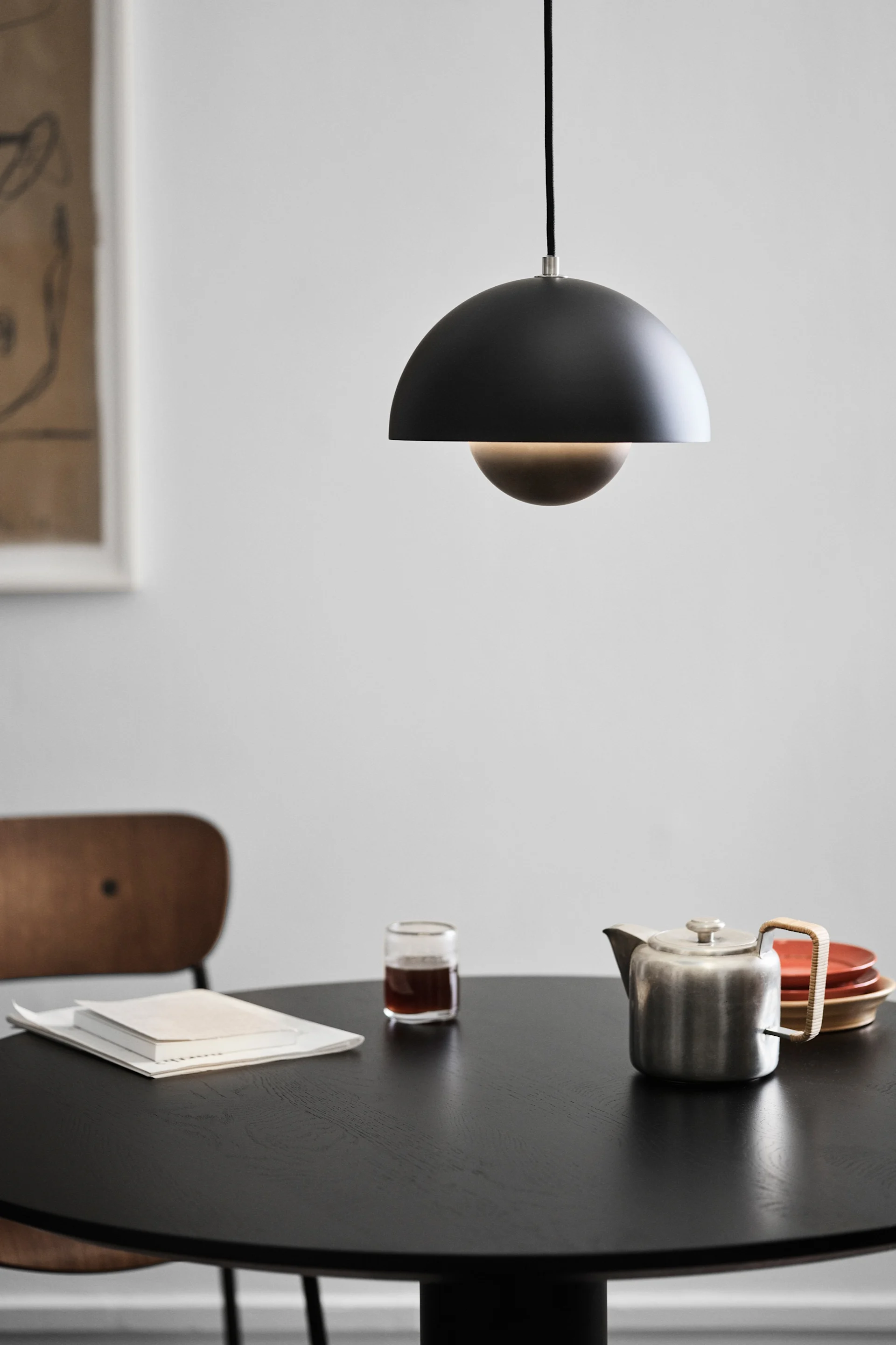 Vous voyez ici une lampe design scandinave, la Flowerpot VP1 de &Tradition, suspendue au-dessus d'une table à manger.