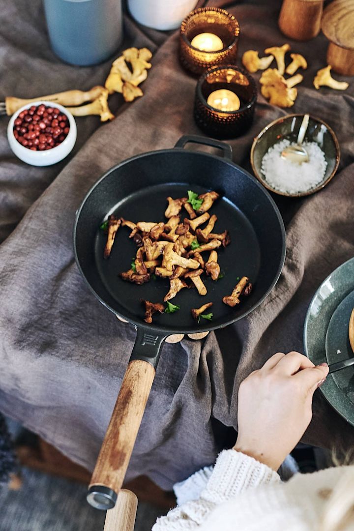 La poêle à frire en fonte Fiskars Norden résiste aux températures élevées et est utilisée ici pour frire les girolles.