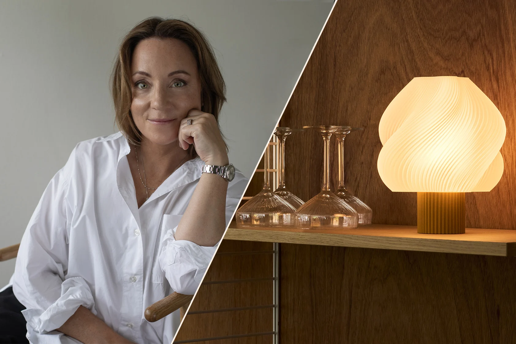 Femme souriante en chemise blanche, menton sur la main, portant une montre, dans un intérieur chaleureux et moderne avec des étagères et une lampe.