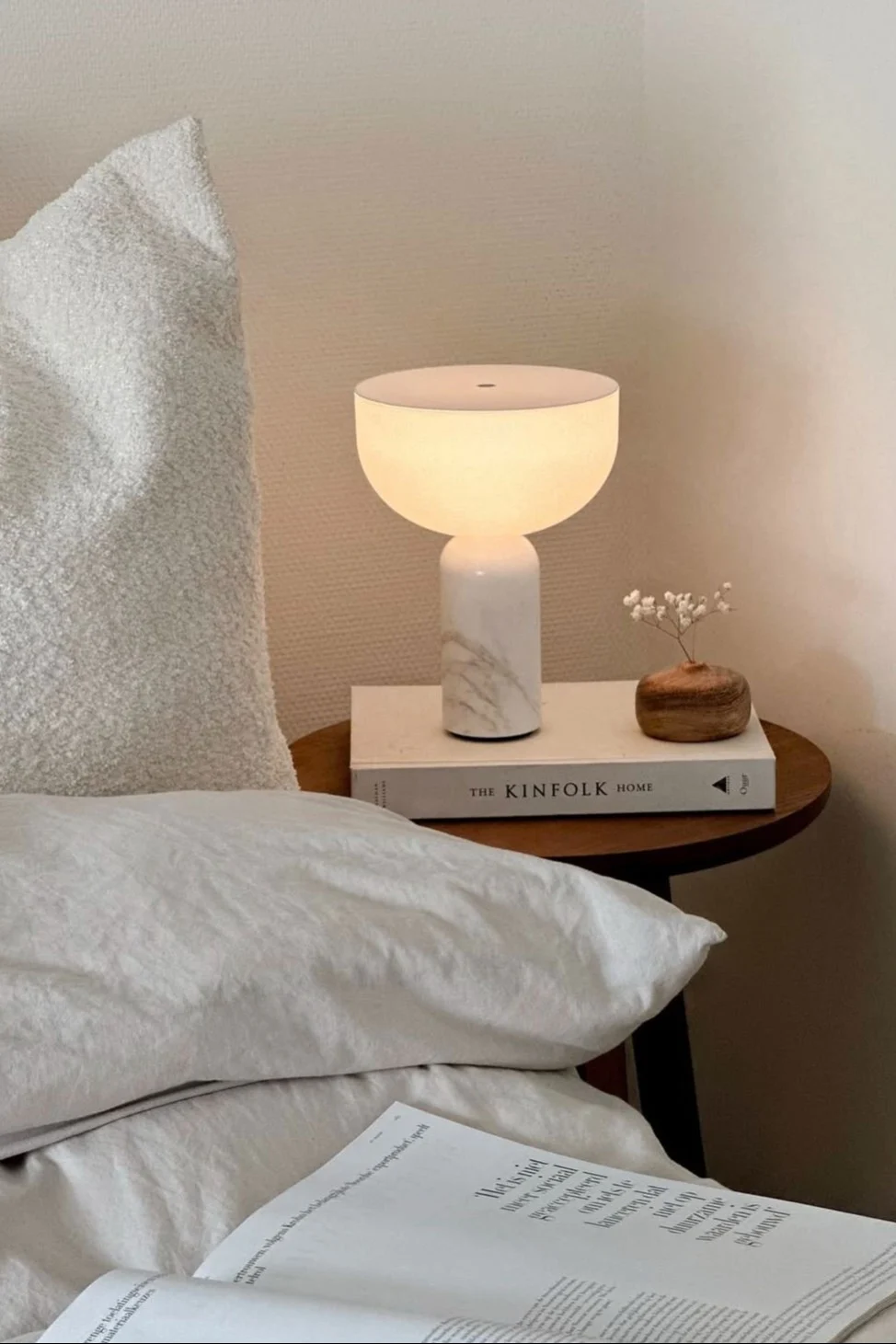 À côté du lit de @wonen.met.lef se trouve un tabouret avec la lampe de table Kizu de New Works.