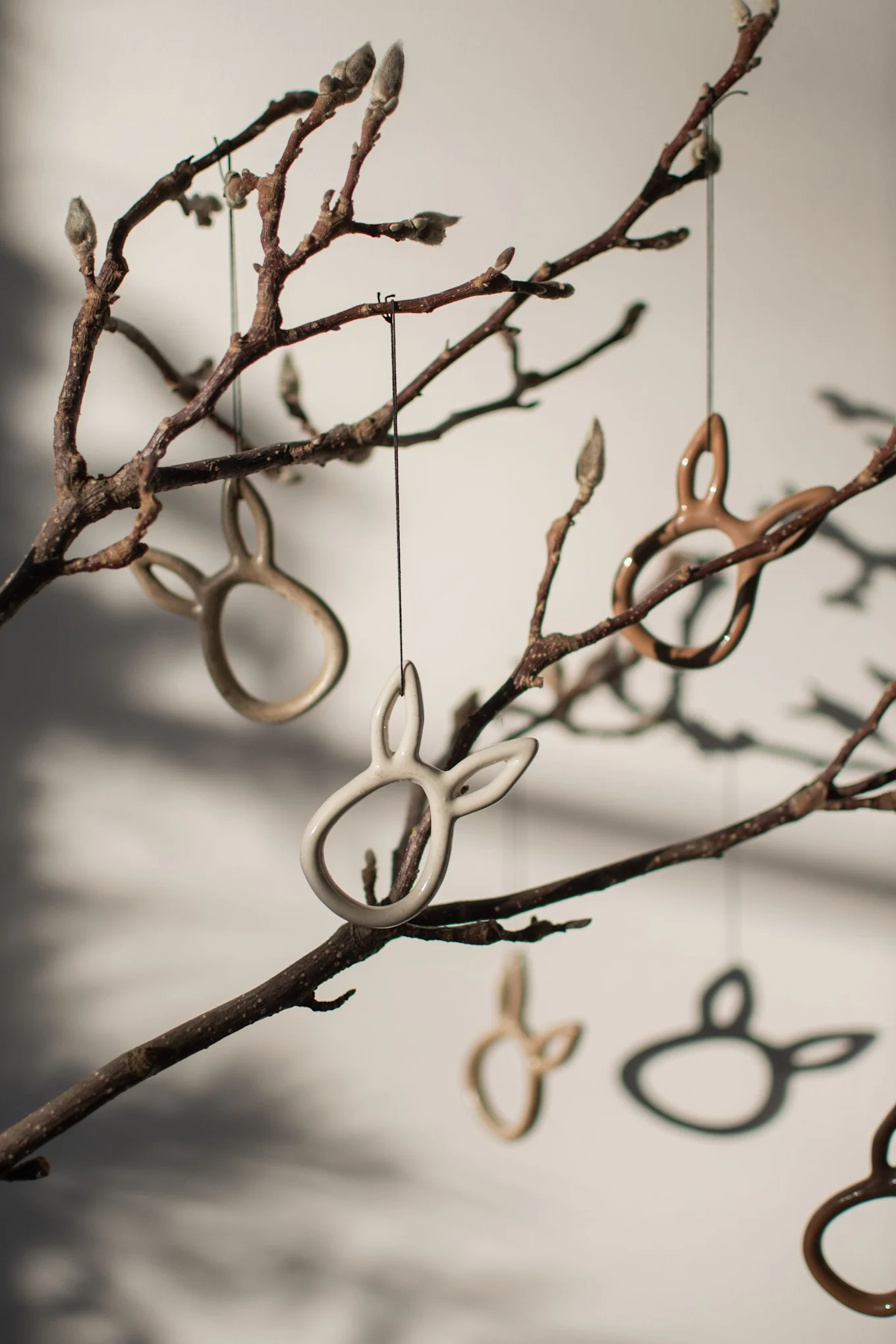 Les pendentifs Sprinkle rabbit Easter de DBKD en forme de lapin sont accrochés à un arbuste.