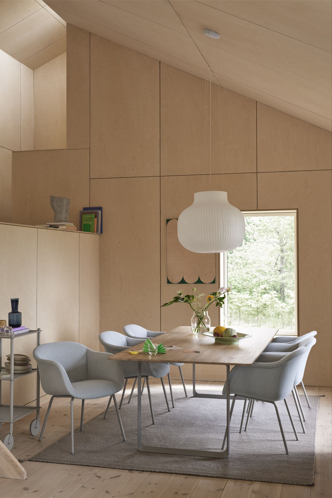 Tapis pour la salle à manger : Le tapis en laine Ply gris de Muuto se trouve dans une salle à manger aménagée dans un style scandinave avec des chaises bleu clair et beaucoup de bois.