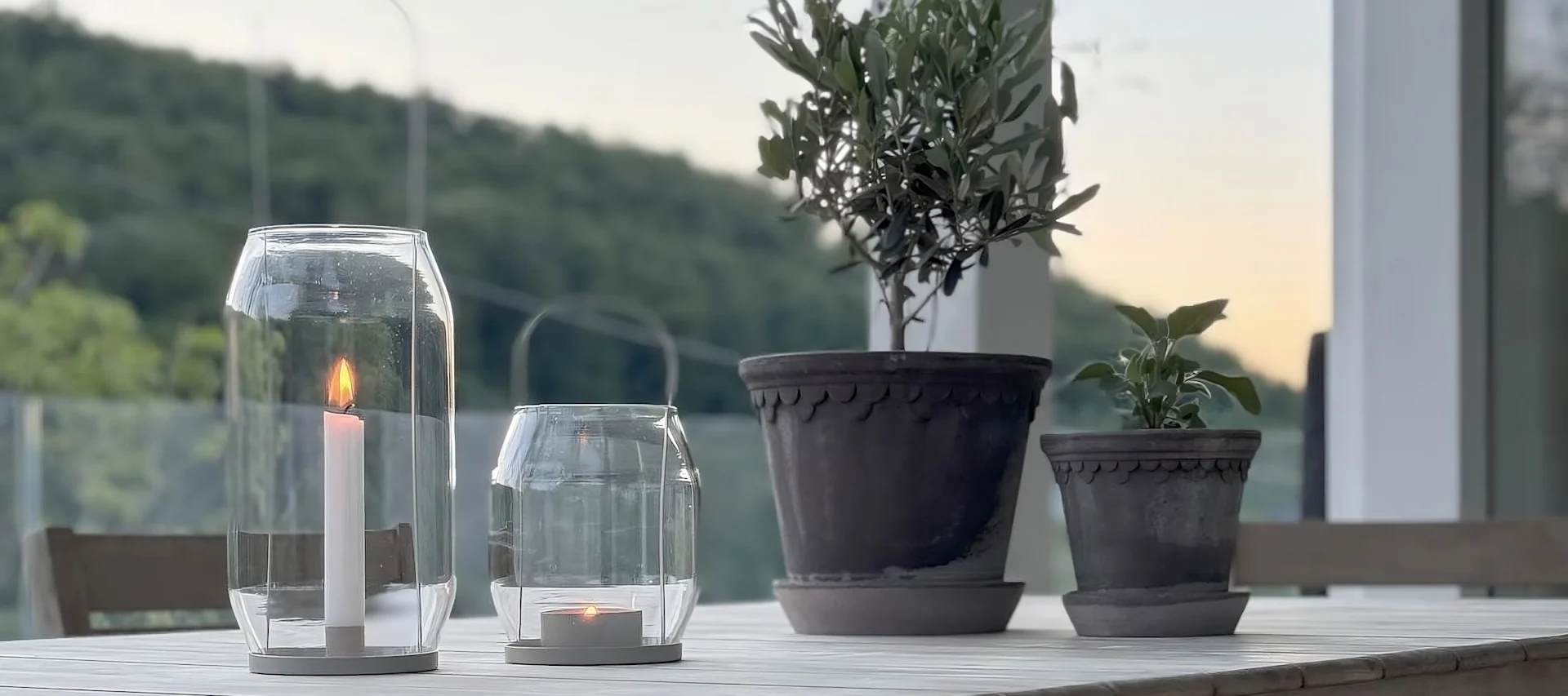 Deux pots de fleurs de Copenhague de Bergs Potter sont posés sur une table, à côté de deux lanternes Ernst sur la terrasse de @zuhauselig.