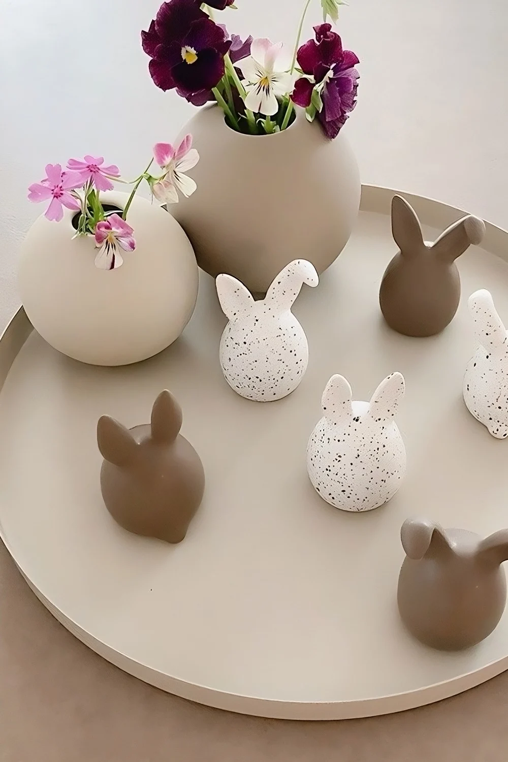 Les triplets de lapins de Pâques en deux couleurs de DBKD sont posés sur un plateau, à côté de deux vases à boules de Cooee Design dans la maison de @sachi_roooom.