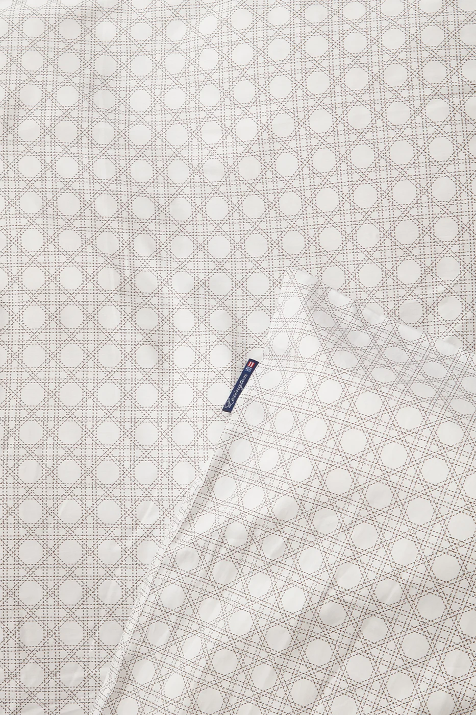 Tissu blanc avec motif en cannage marron clair et une étiquette bleue Lexington.