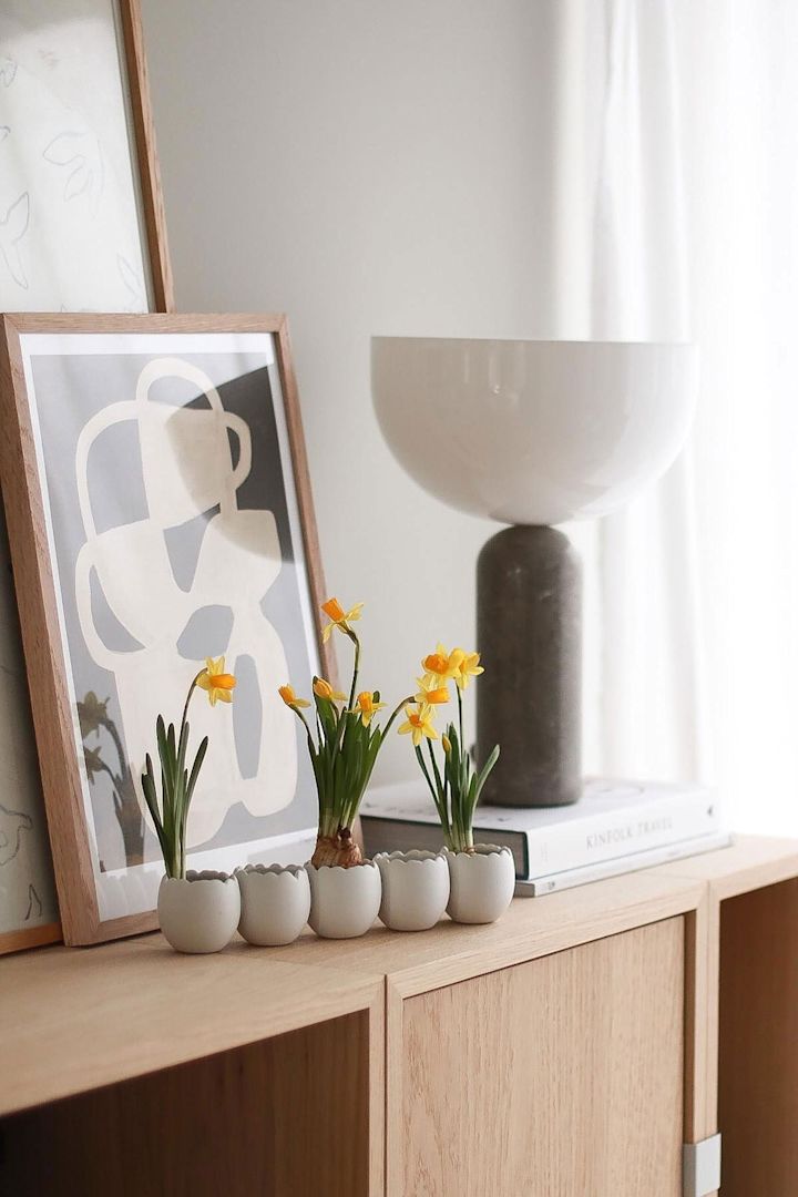 La décoration de Pâques Easter line est plantée de fleurs et se trouve sur une commode dans la maison de @picsbyellen.