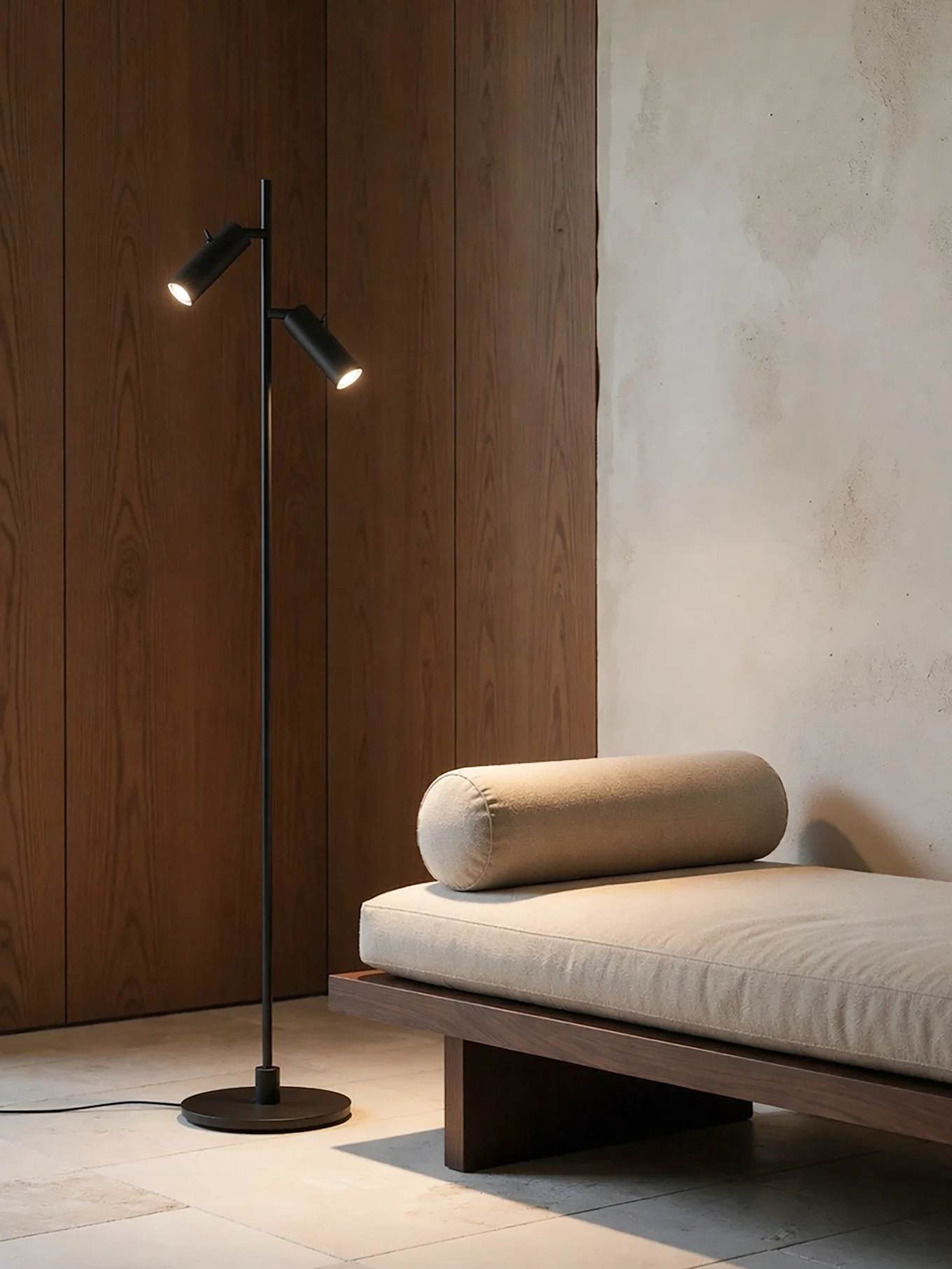 Une pièce moderne avec un lampadaire noir à deux lumières à côté d'un daybed en bois avec un coussin et un traversin beige clair.