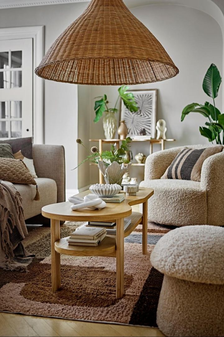 La décoration bohème se caractérise notamment par des éléments en rotin et des plantes. Vous voyez ici un salon décoré dans le style bohème avec des produits Bloomingville.