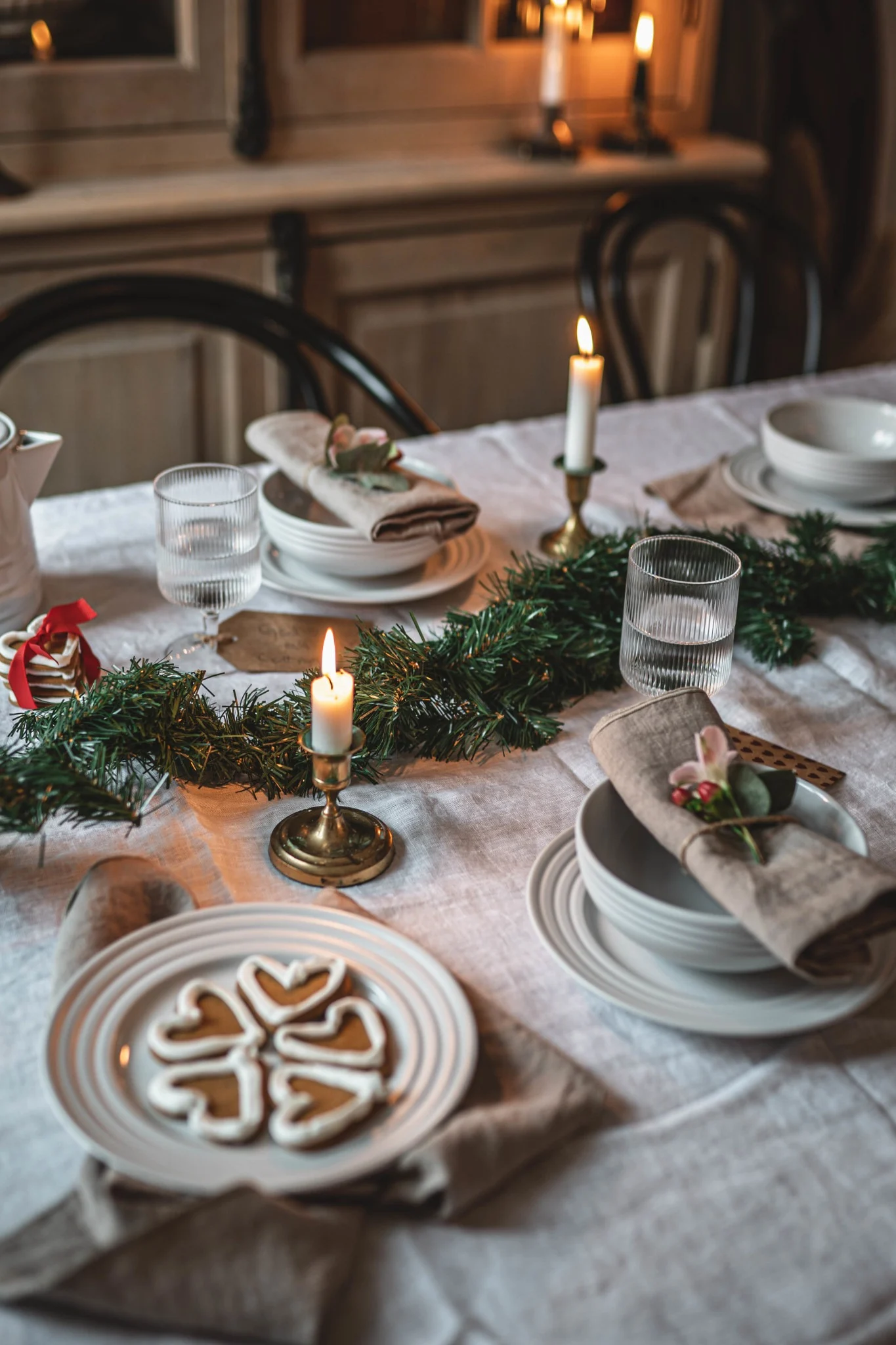 Une table confortable, décorée pour Noël, avec de la vaisselle NJRD et des pains d'épices suédois.