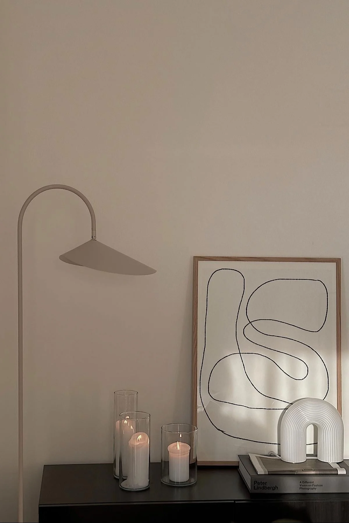 La commode de @helenas.hem, décorée de bougies, d'une photo, de la lampe de table Vuelta, à côté de laquelle se trouve le lampadaire Arum.