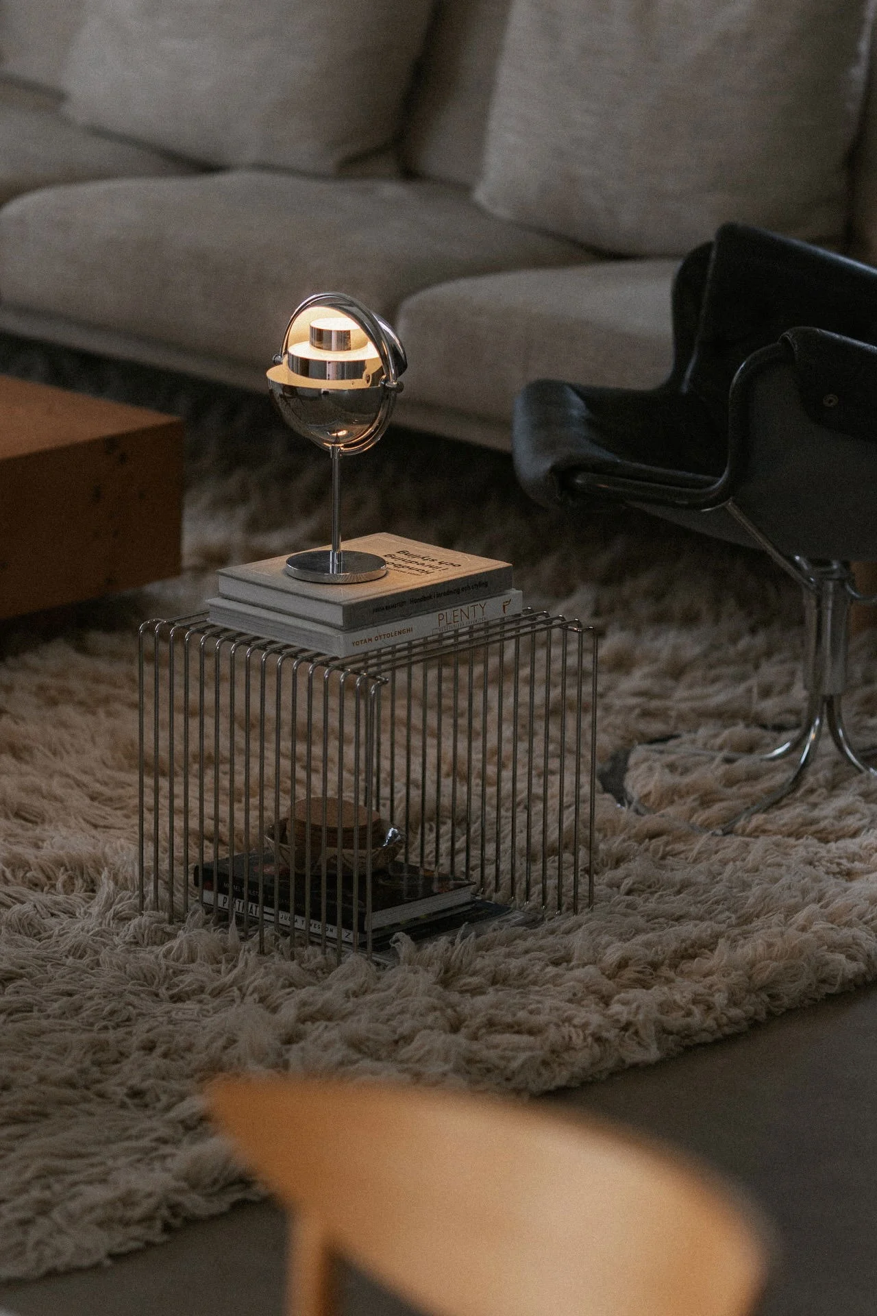 Lampes scandinaves : la lampe de table Multi-Lite chromée de Gubi trône dans un salon, posée sur une étagère Panton Wire.