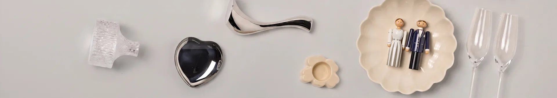 Objets décoratifs: bouton en verre, cœur argenté, poignée courbée, plat fleur, figurines mariés, flûtes à champagne.