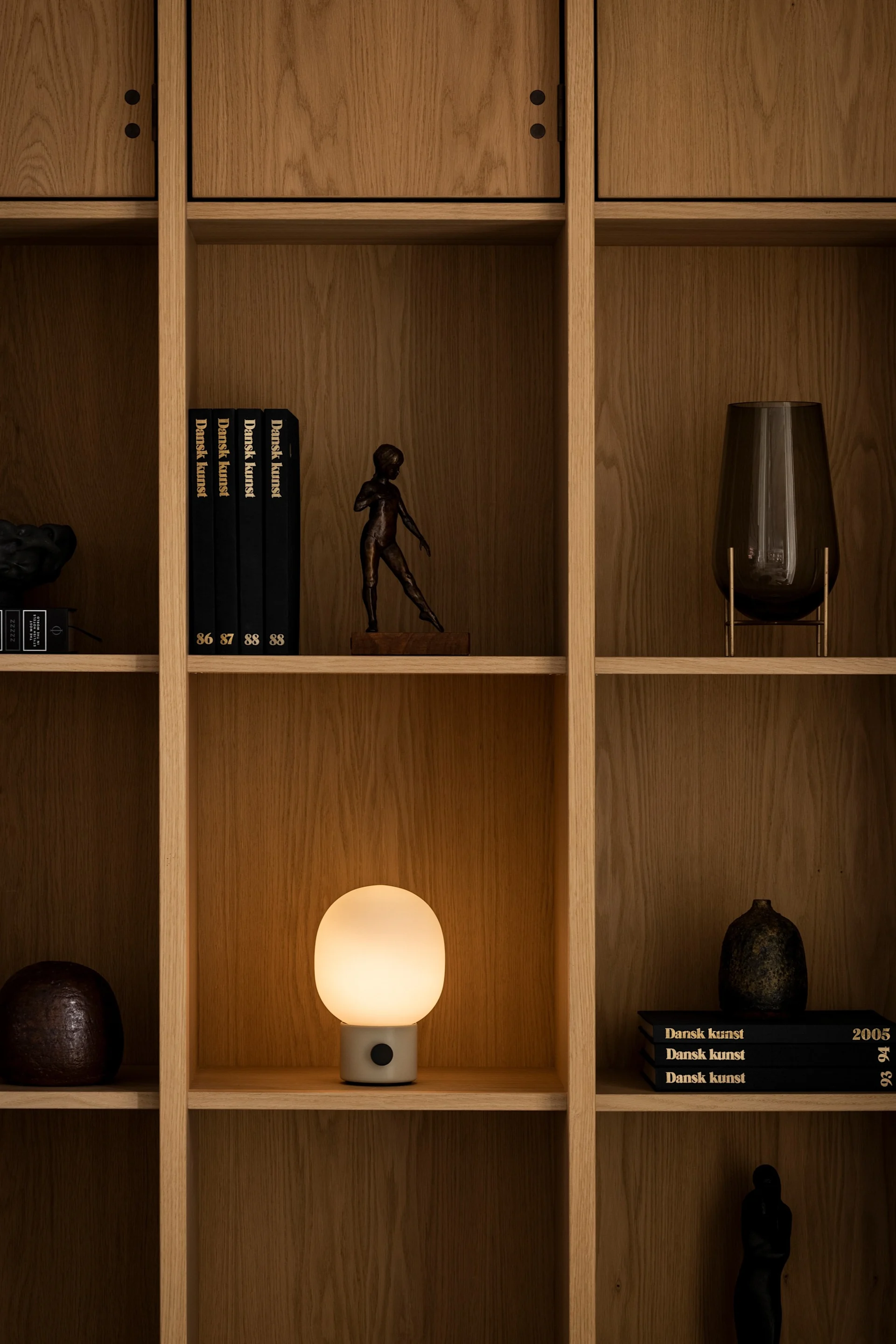 La lampe de table JWDA d'Audo Copenhagen est posée sur une étagère.