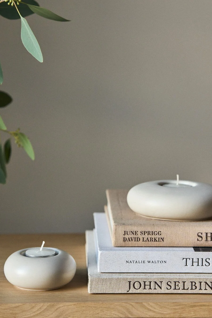 Lagom : une pile de livres sur laquelle est posé un photophore Stone de Scandi Living.
