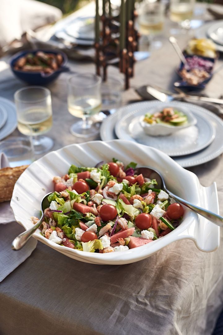 Des recettes estivales simples comme la salade que vous voyez ici avec de la pastèque et des écrevisses dans un bol en forme de coquillage.