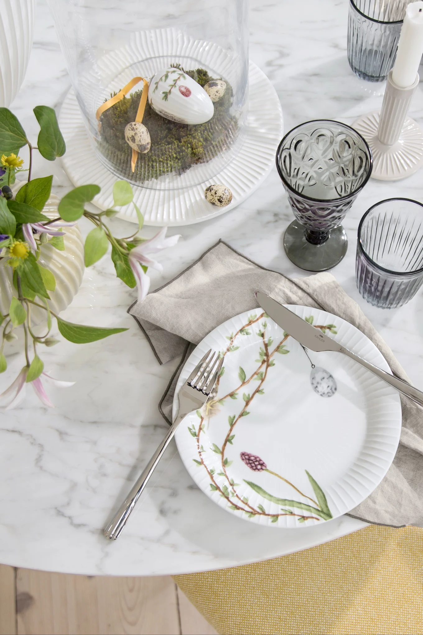 Décoration de table pour Pâques : L'assiette de Pâques Hammershøi de Kähler, décorée de motifs de Pâques, trône sur une table dressée pour Pâques.